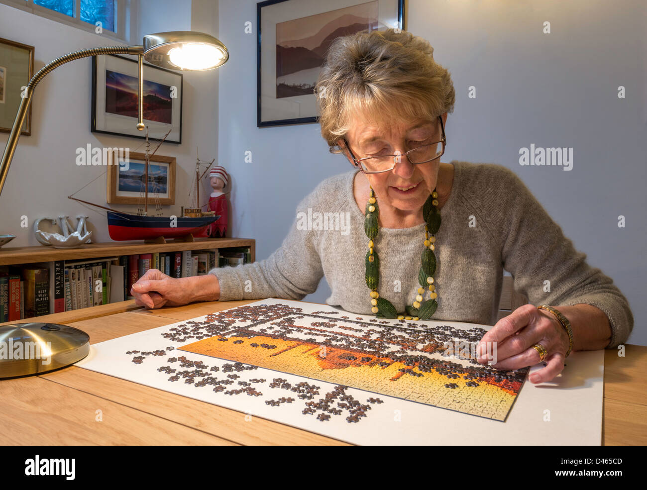 Elderly woman, OAP with jigsaw at home UK Stock Photo