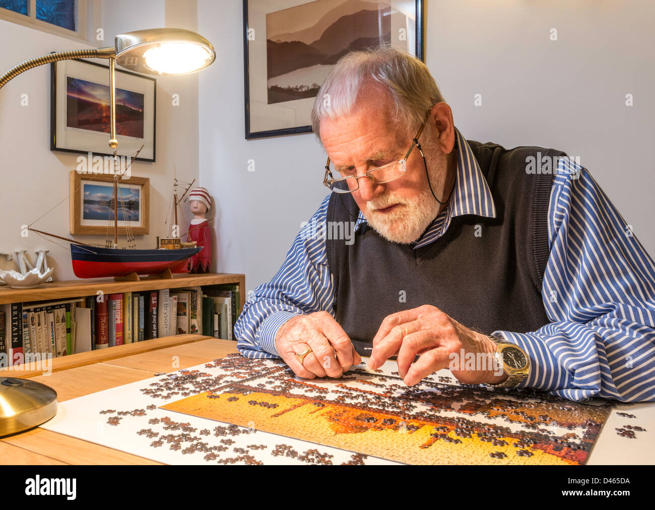 Retired man, OAP, with jigsaw puzzle at home. UK Stock Photo