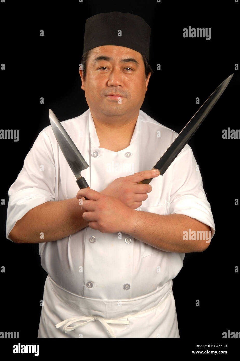 Male Japanese sushi chef posing with knives Stock Photo