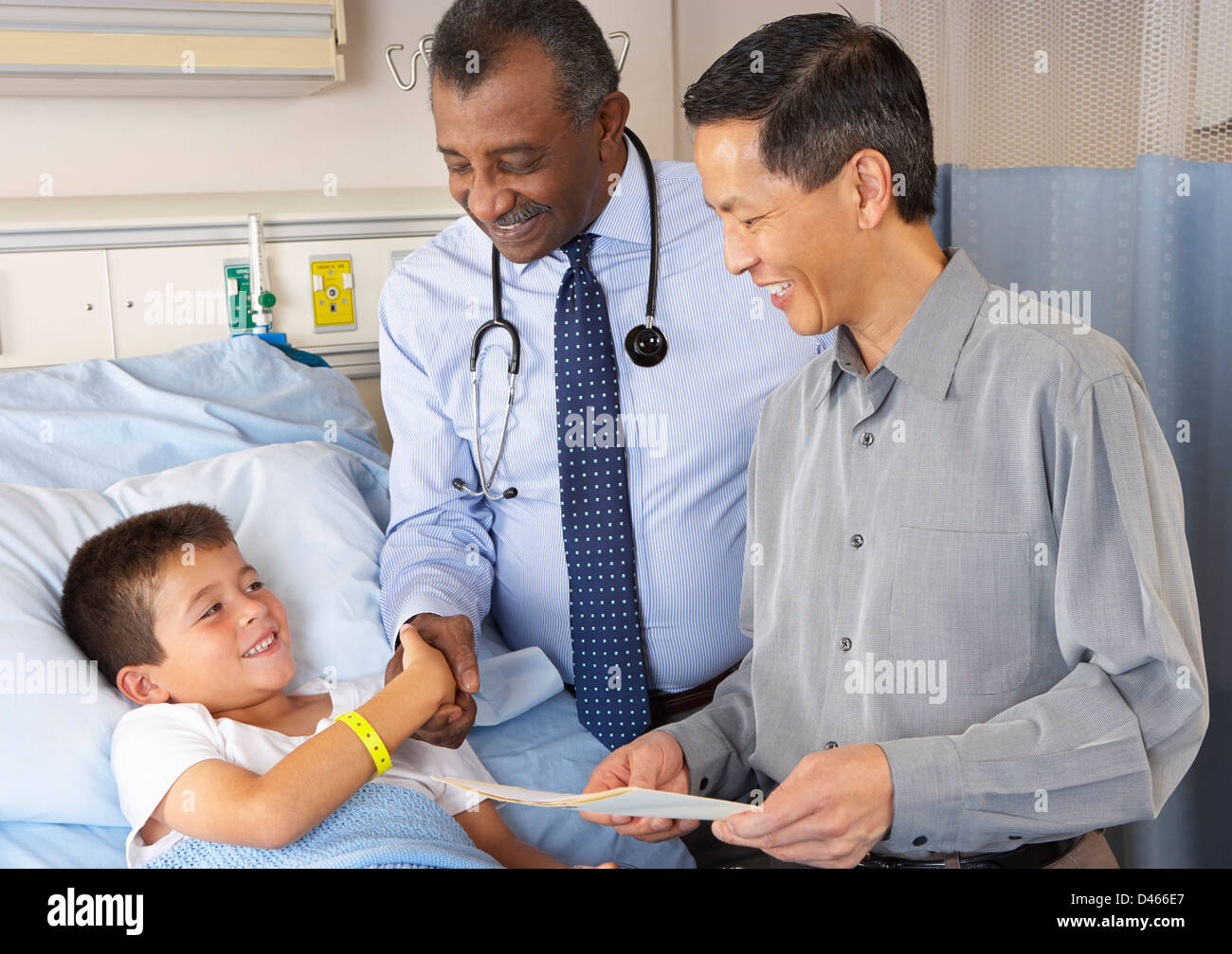 Doctors Visiting Child Patient On Ward Stock Photo