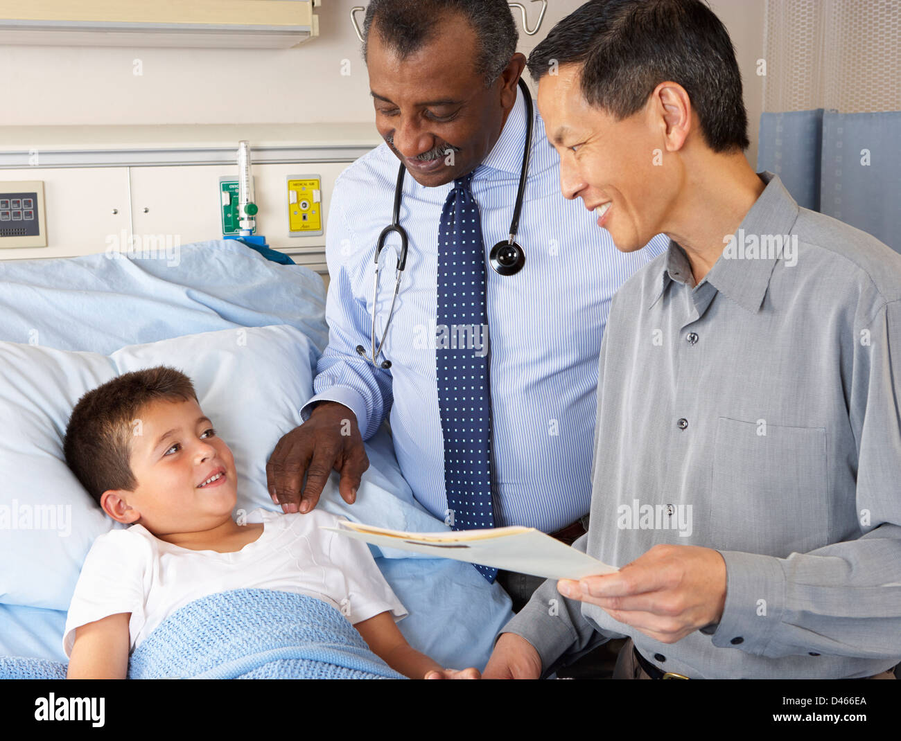 Doctors Visiting Child Patient On Ward Stock Photo