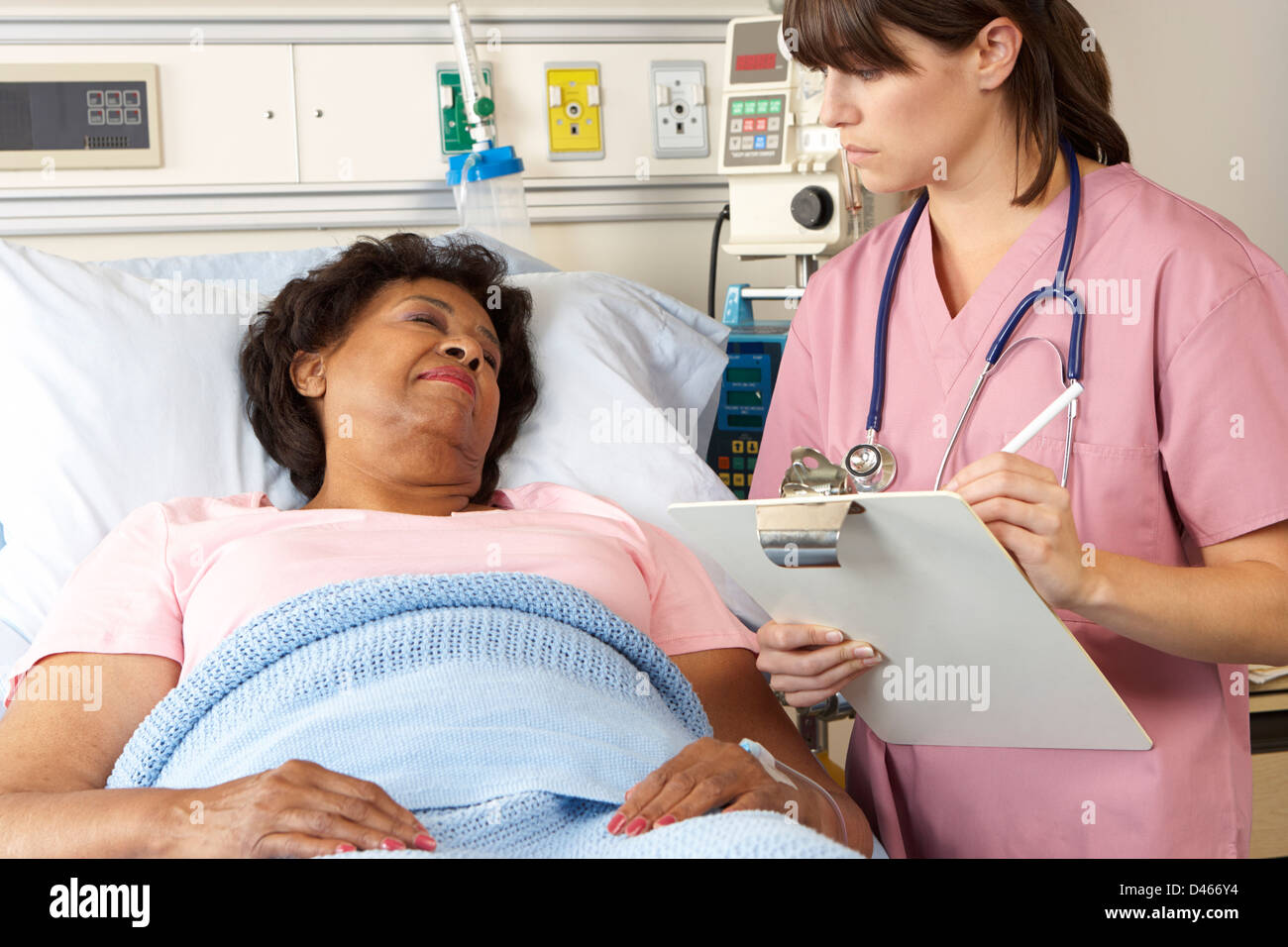 Nurse Visiting Senior Female Patient On Ward Stock Photo - Alamy