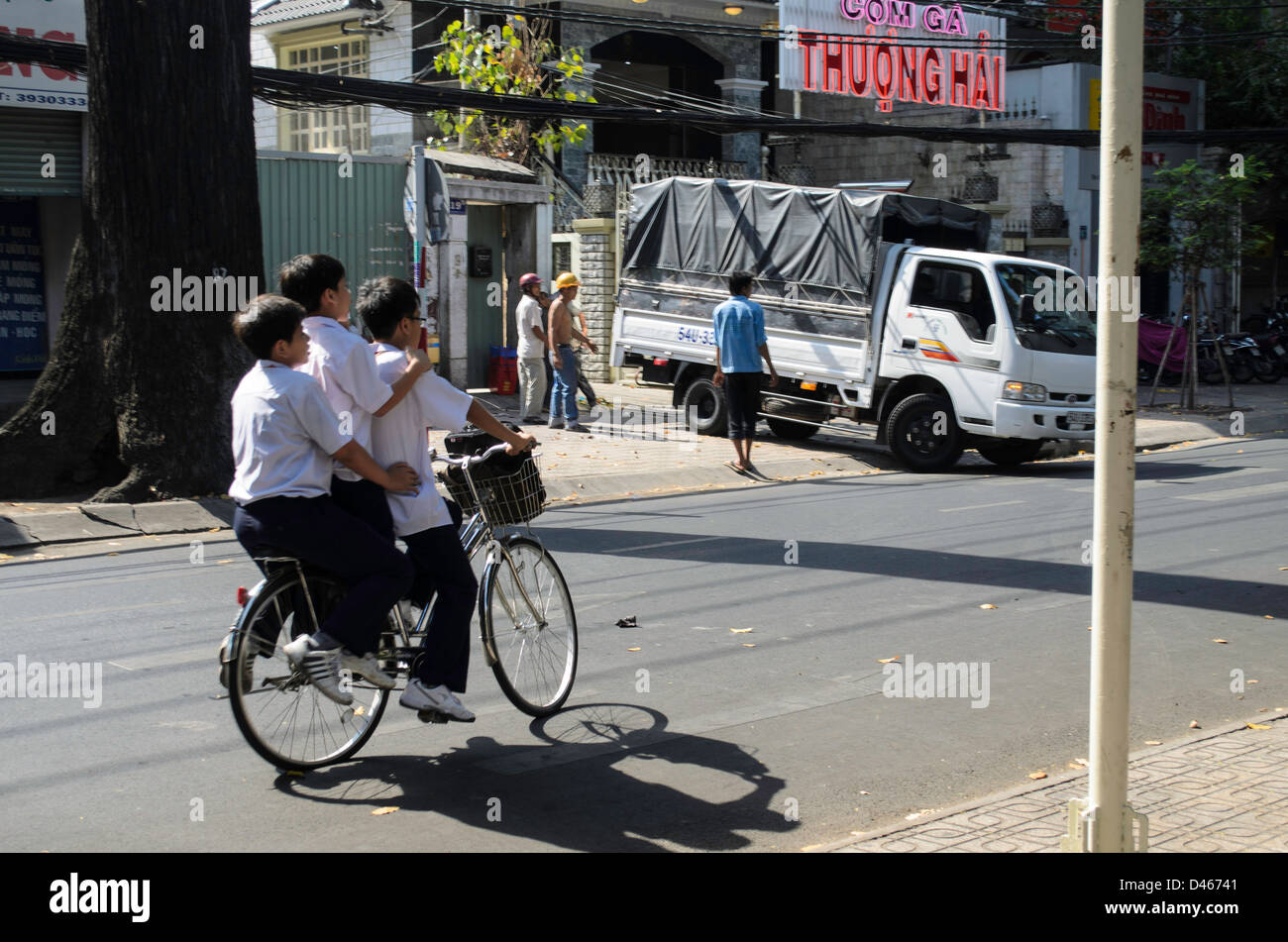 Three boys on a bicycle in Ho Chi Minh City in Vietnam Stock Photo