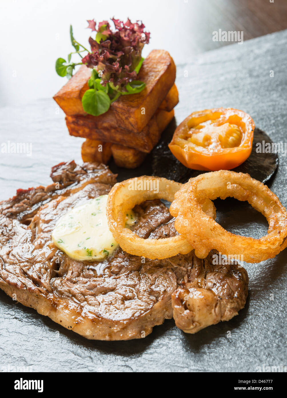 Steak and onion rings, served with chunky chips Stock Photo Alamy