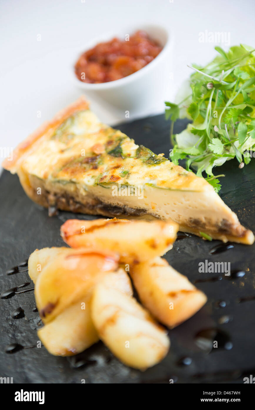 Mushroom and Cheese Quiche served with chips and relish Stock Photo