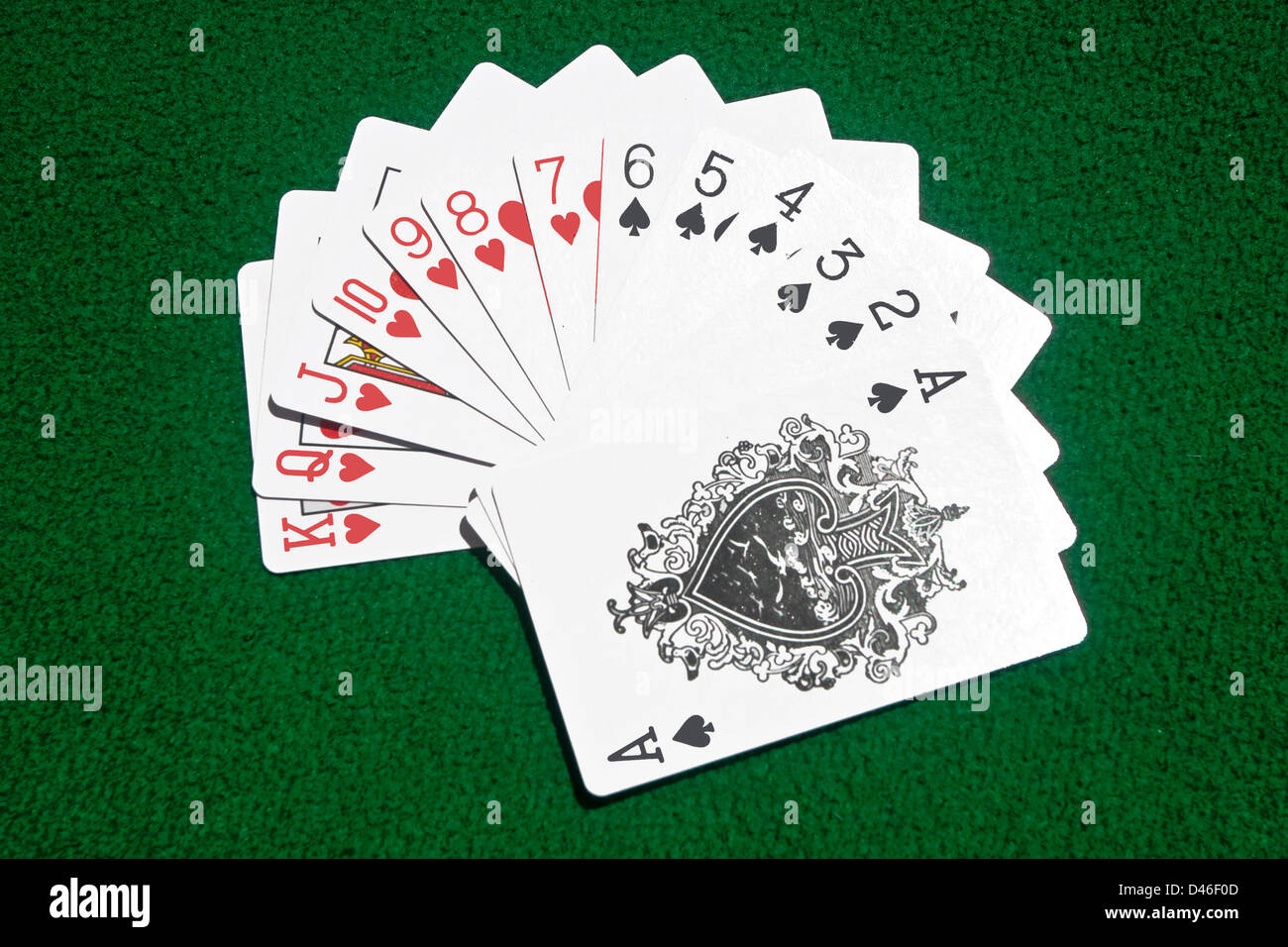 Playing cards of Hearts and Spades put streetwise on the playing table. Stock Photo