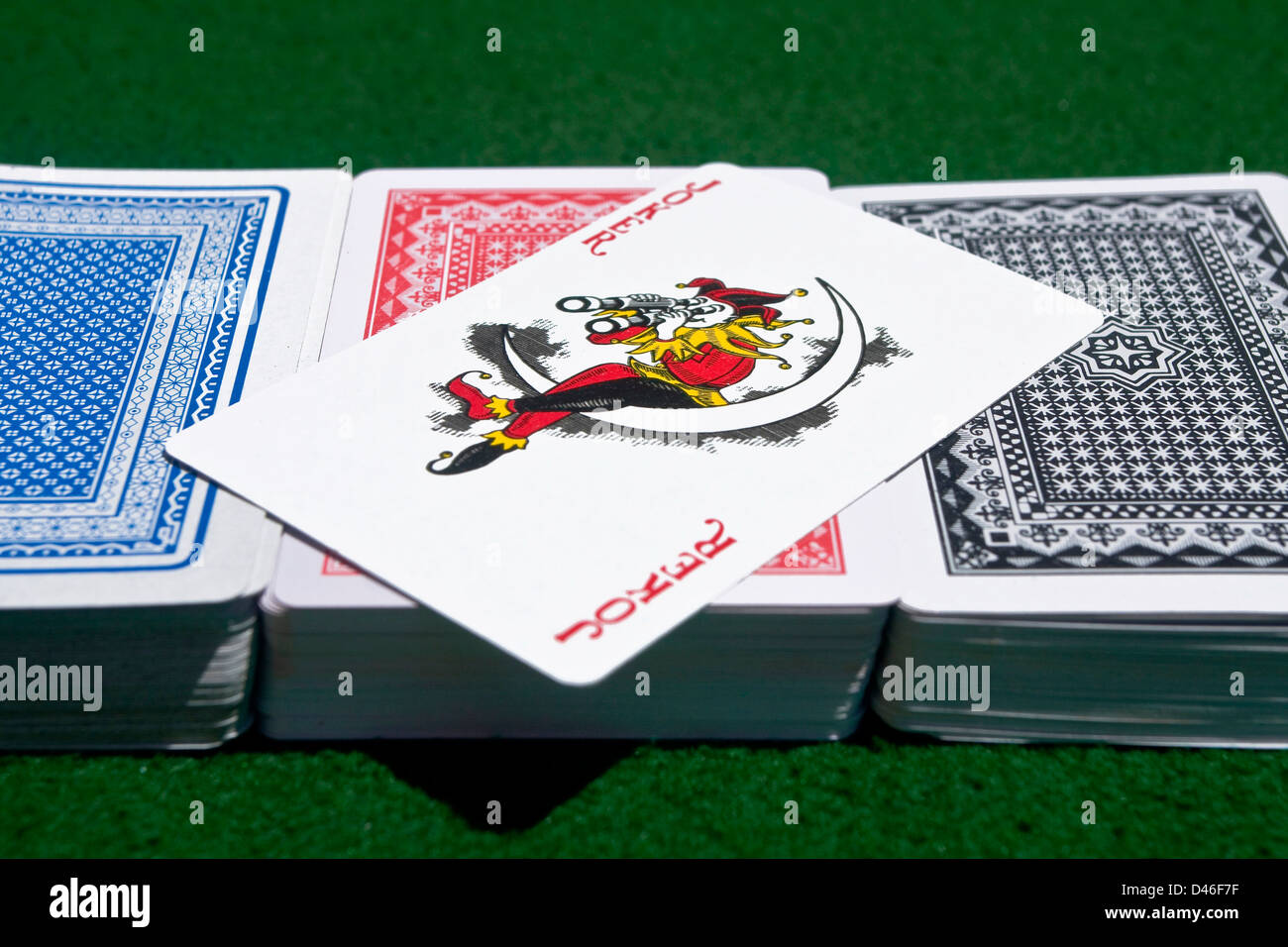 Three differentcolor decks of cards with a red Joker across Stock