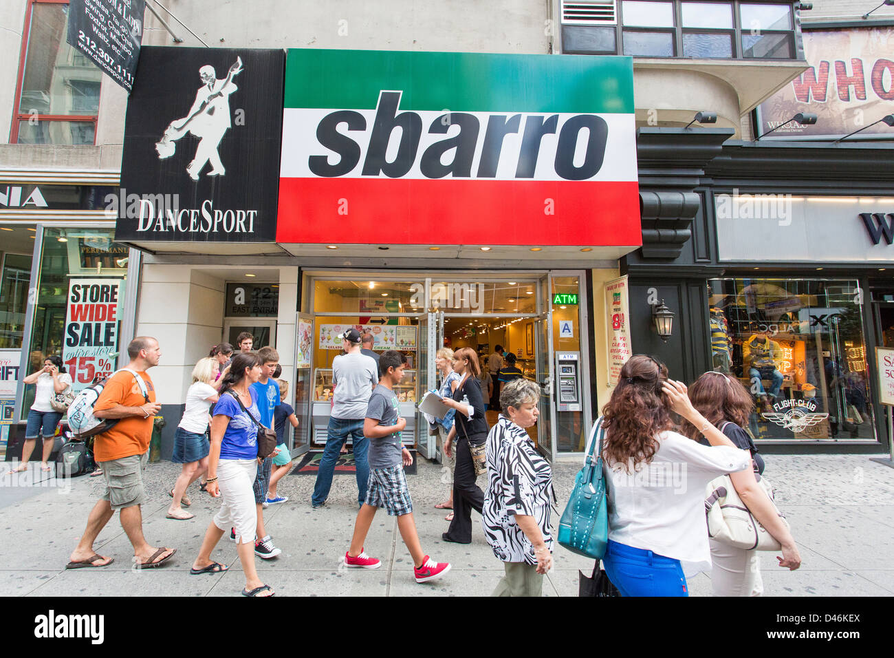 People walking on the sidewalk at the front of Sbarro pizzeria in New York City Stock Photo