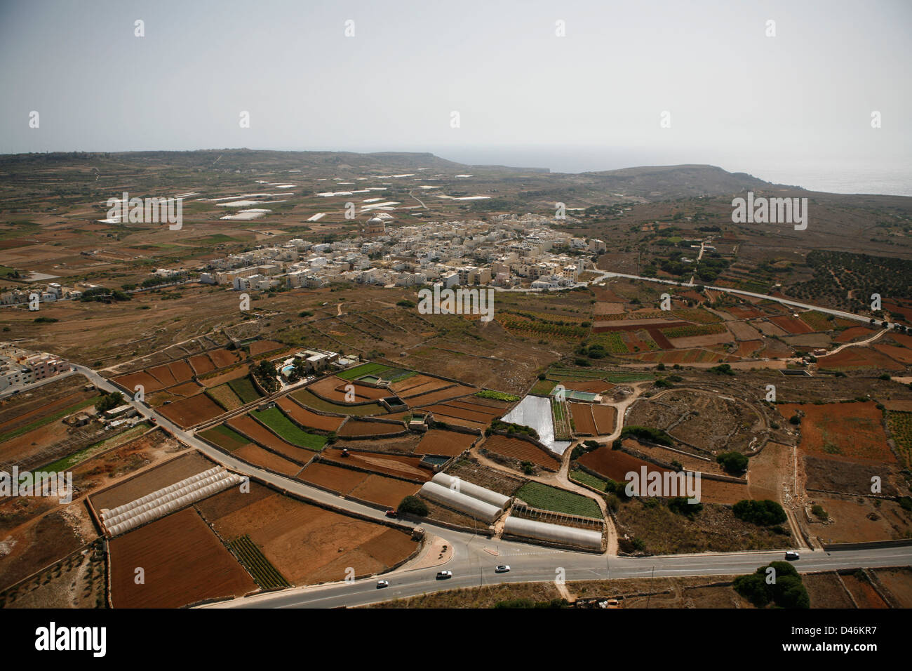 Town in Malta from the air, surrounded by farm land and industry Stock