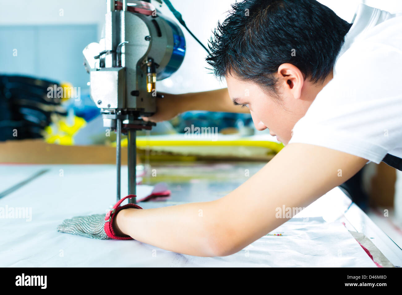 worker using a cutter a large machine for cutting fabrics in a
