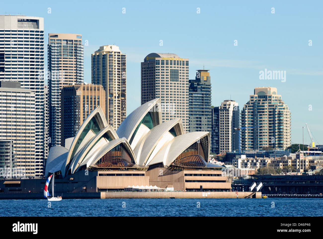 Sydney Opera House with Sydney Harbour (Sydney Harbor) in front and skyscrapers behind Stock Photo
