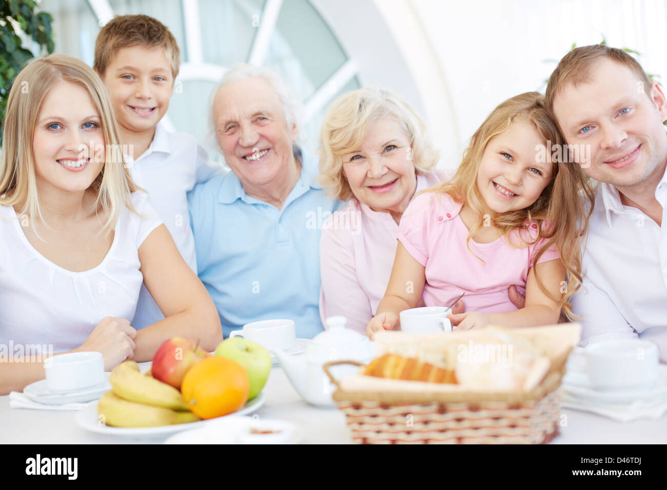 Portrait of senior and young couples with their children having dinner at home Stock Photo