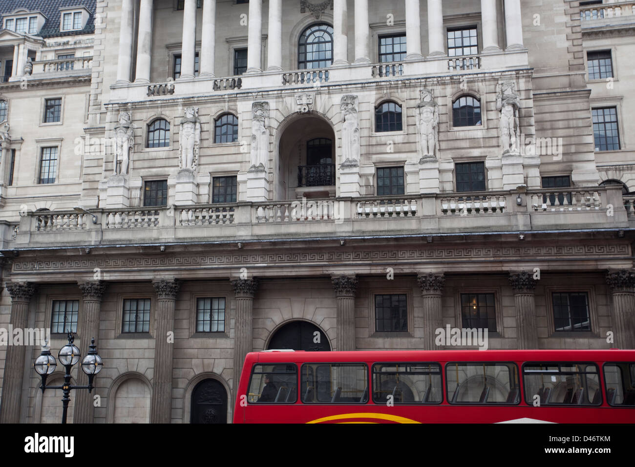 Traditional red double decker bus with London architecture in the background. Stock Photo