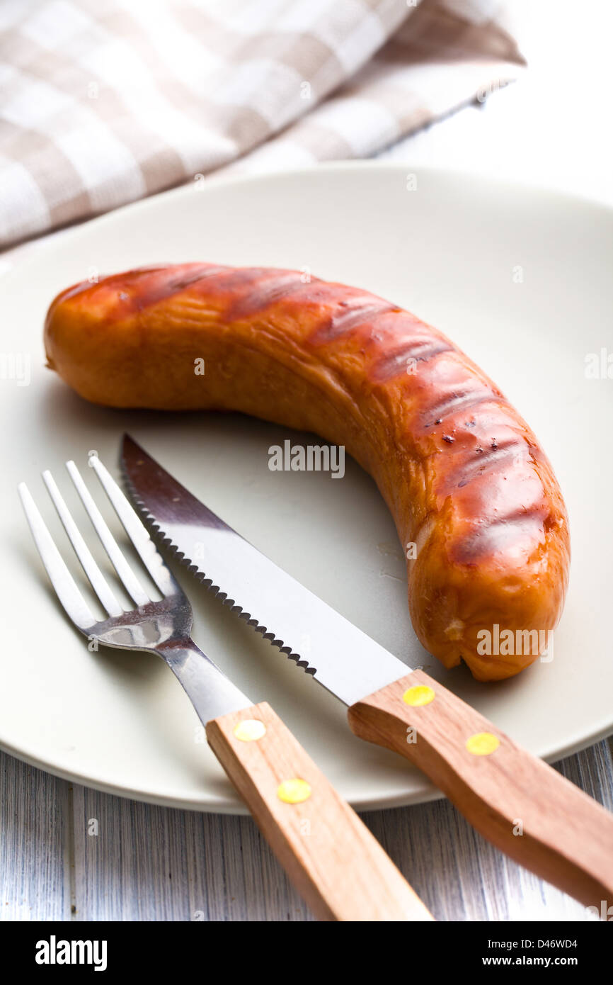 grilled sausage on plate with cutlery Stock Photo Alamy