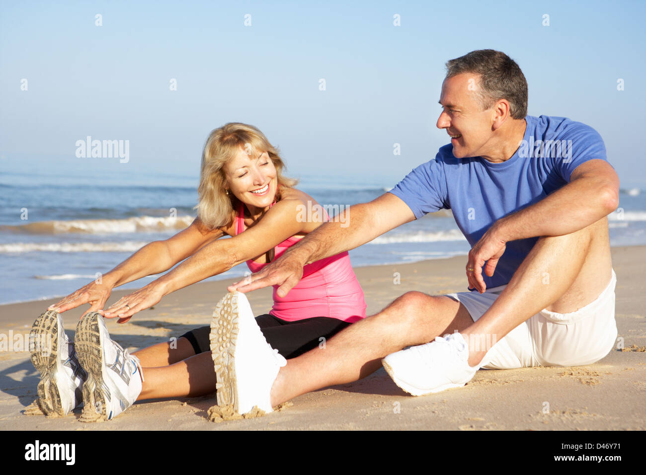Senior Couple Exercising On Beach Stock Photo