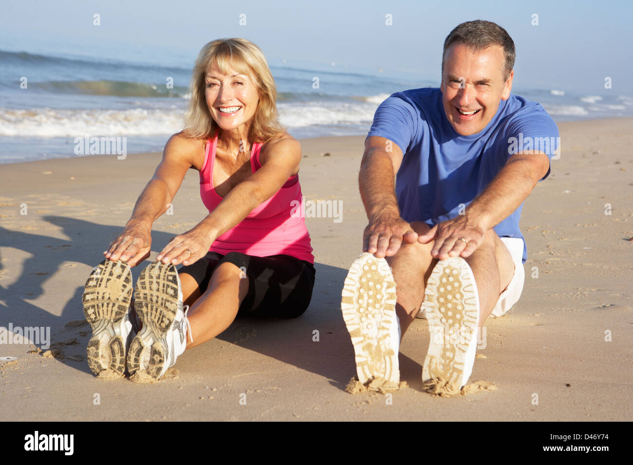 Senior Couple Exercising On Beach Stock Photo