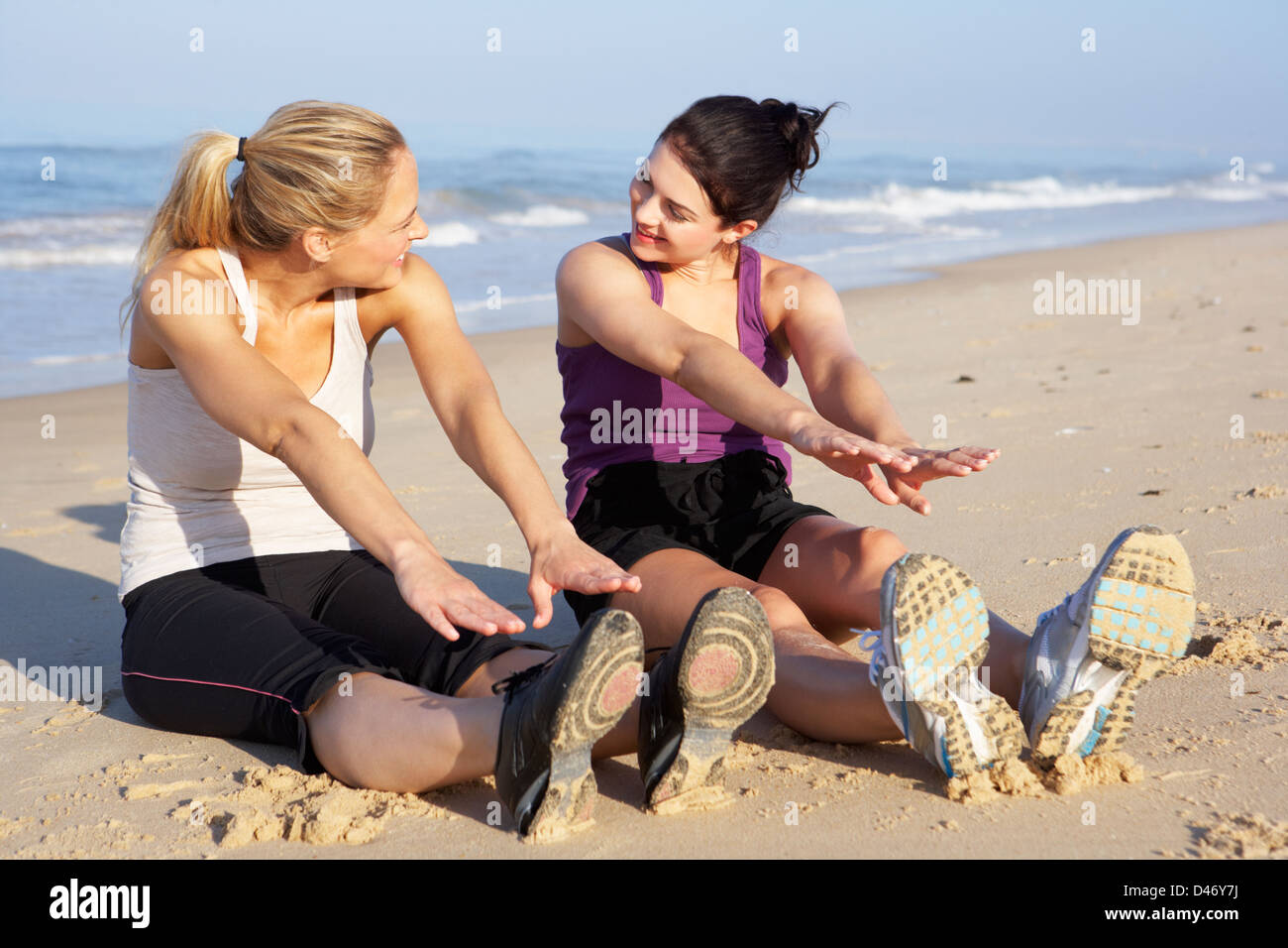Two Women Exercising On Beach Stock Photo