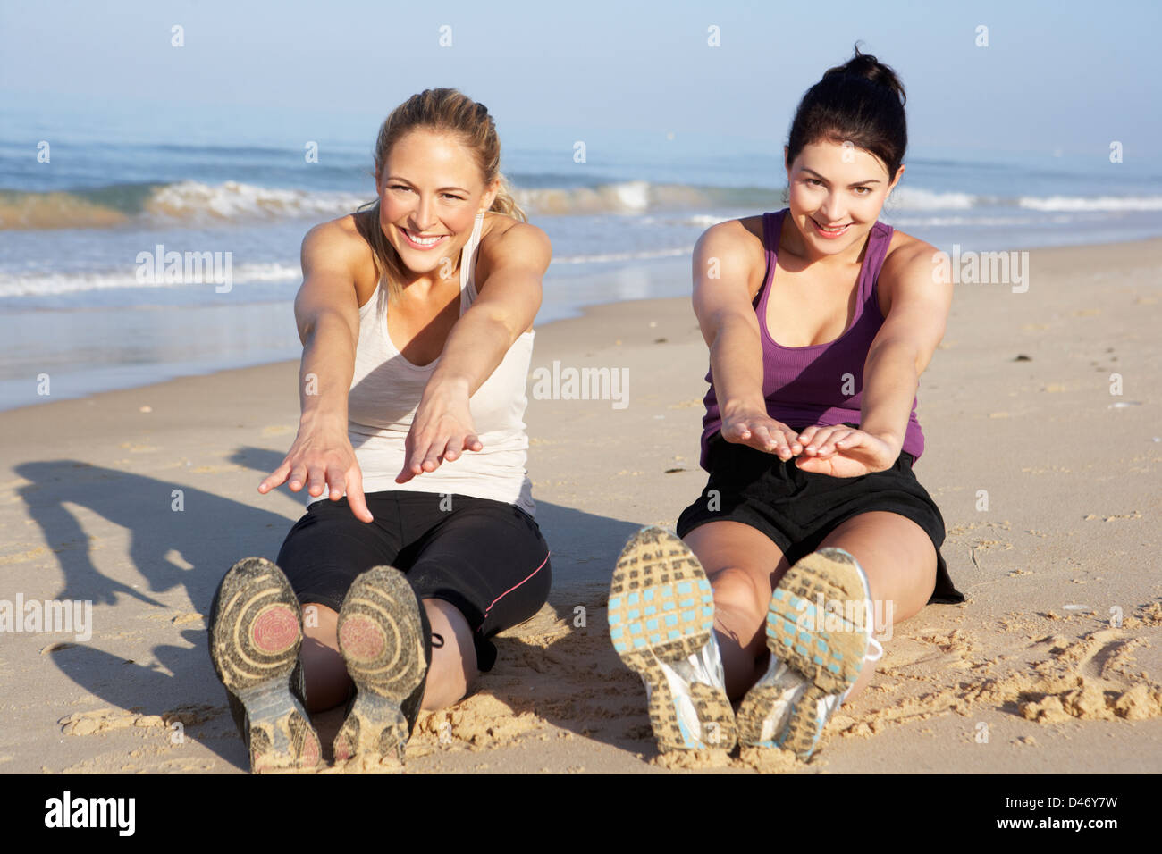 Two Women Exercising On Beach Stock Photo