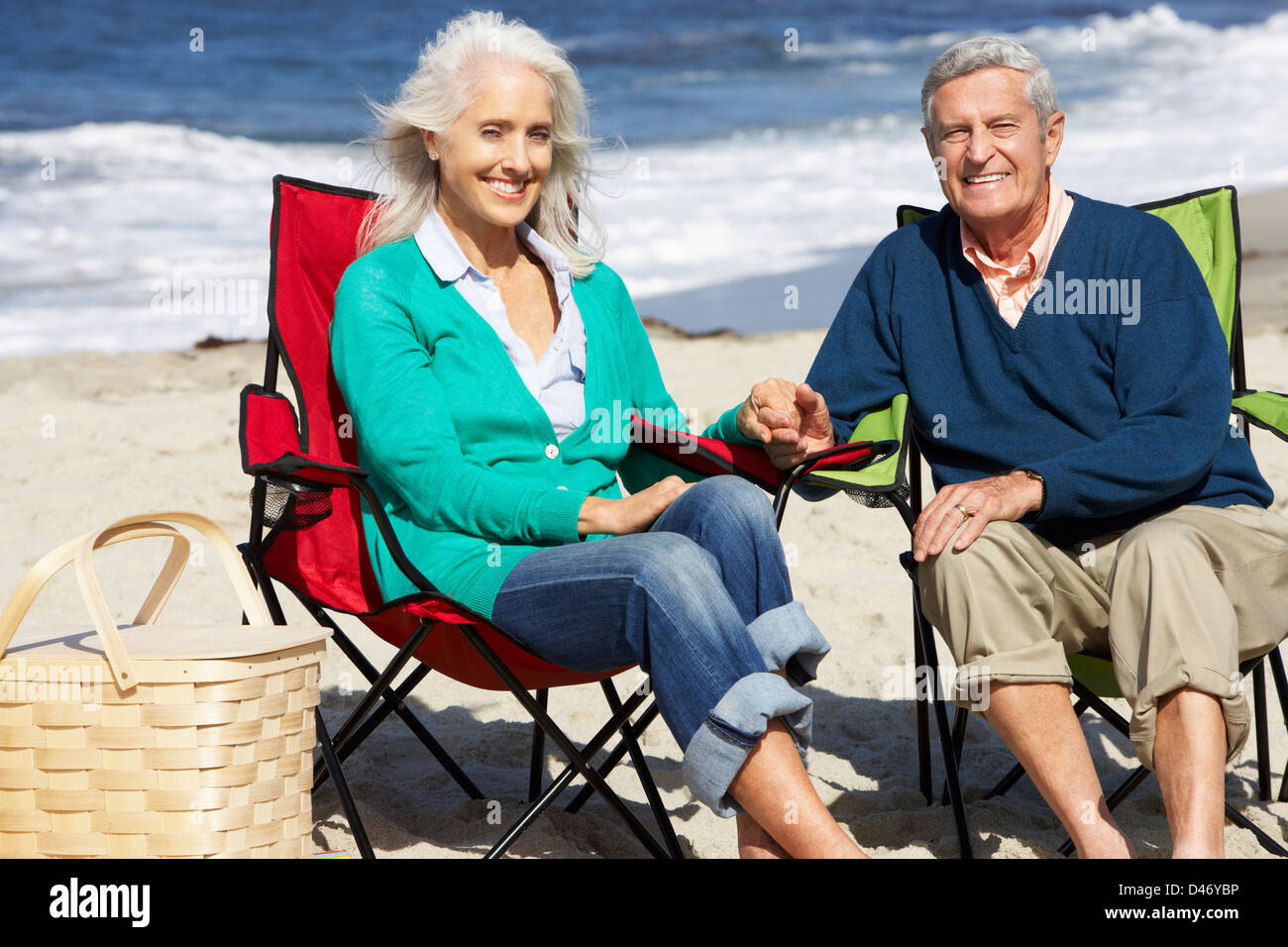 Senior Couple Sitting On Beach In Deckchairs Having Picnic Stock Photo ...