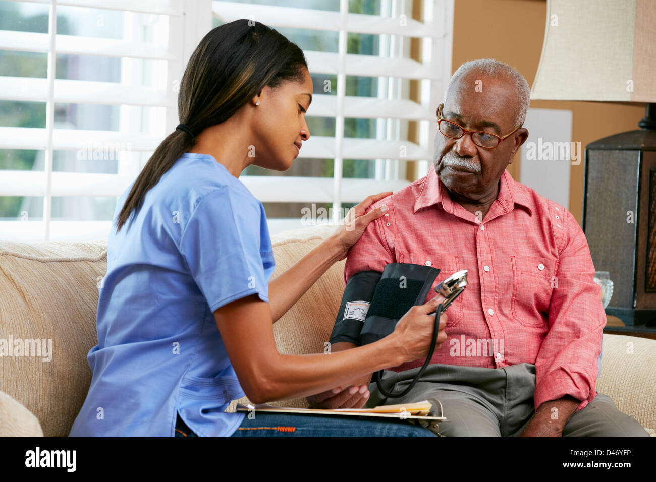 Nurse Visiting Senior Male Patient At Home Stock Photo