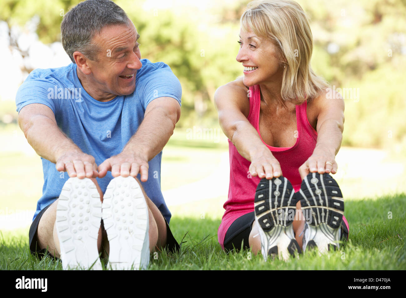 Senior Couple Exercising In Park Stock Photo
