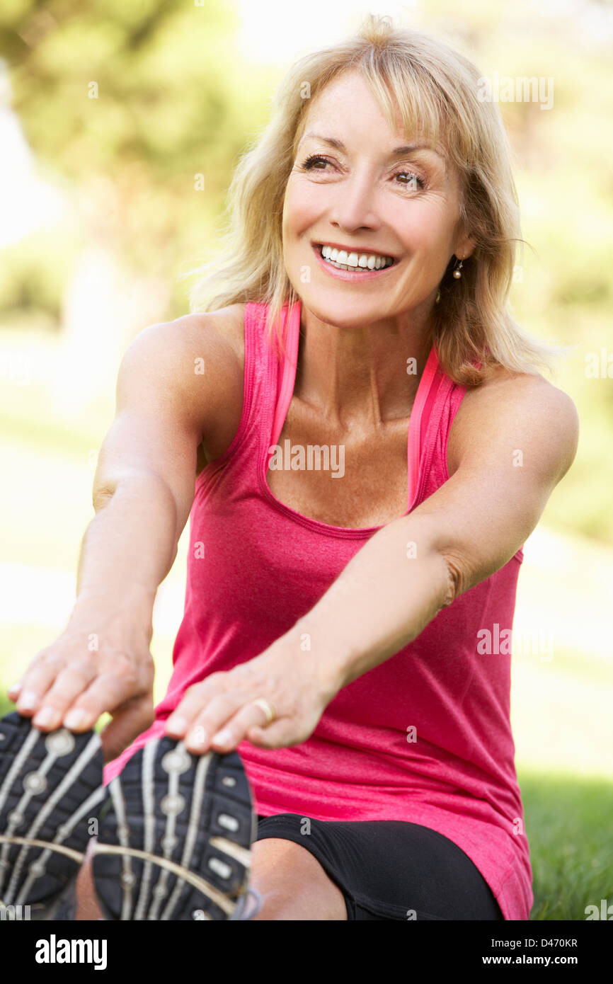 Senior Woman Exercising In Park Stock Photo