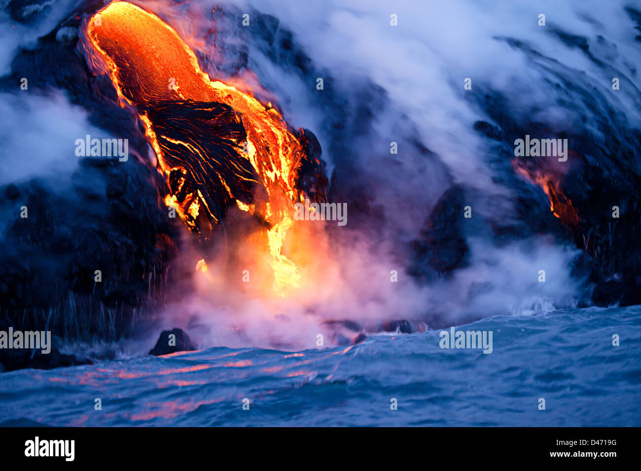 The Pahoehoe lava flowing from Kilauea has reached the Pacific ocean near Kalapana, Big Island, Hawaii. Stock Photo