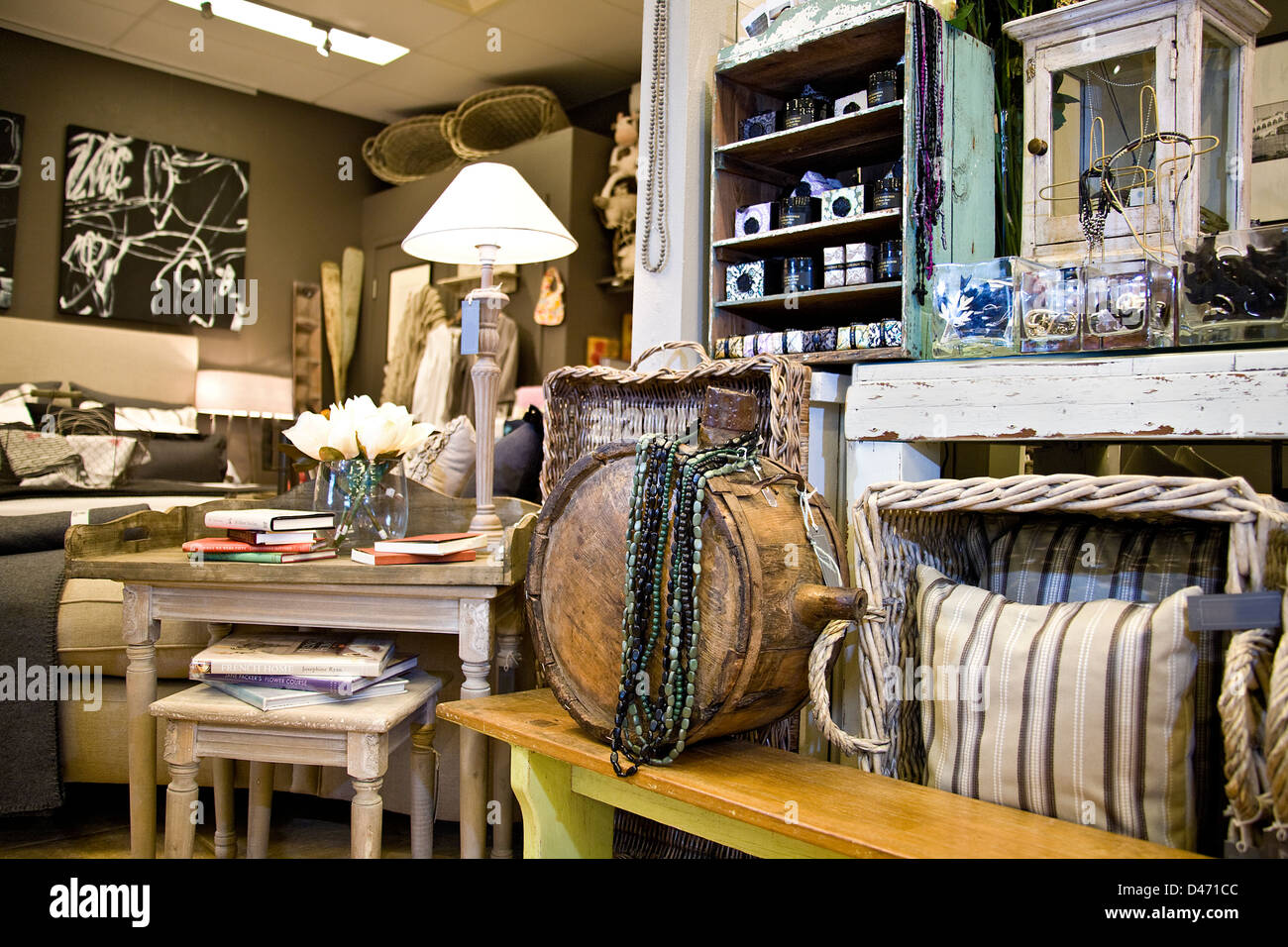 Image of a store's homewares display, water canteen, cushions and cane baskets in foreground, desks lamps, bedding in background Stock Photo