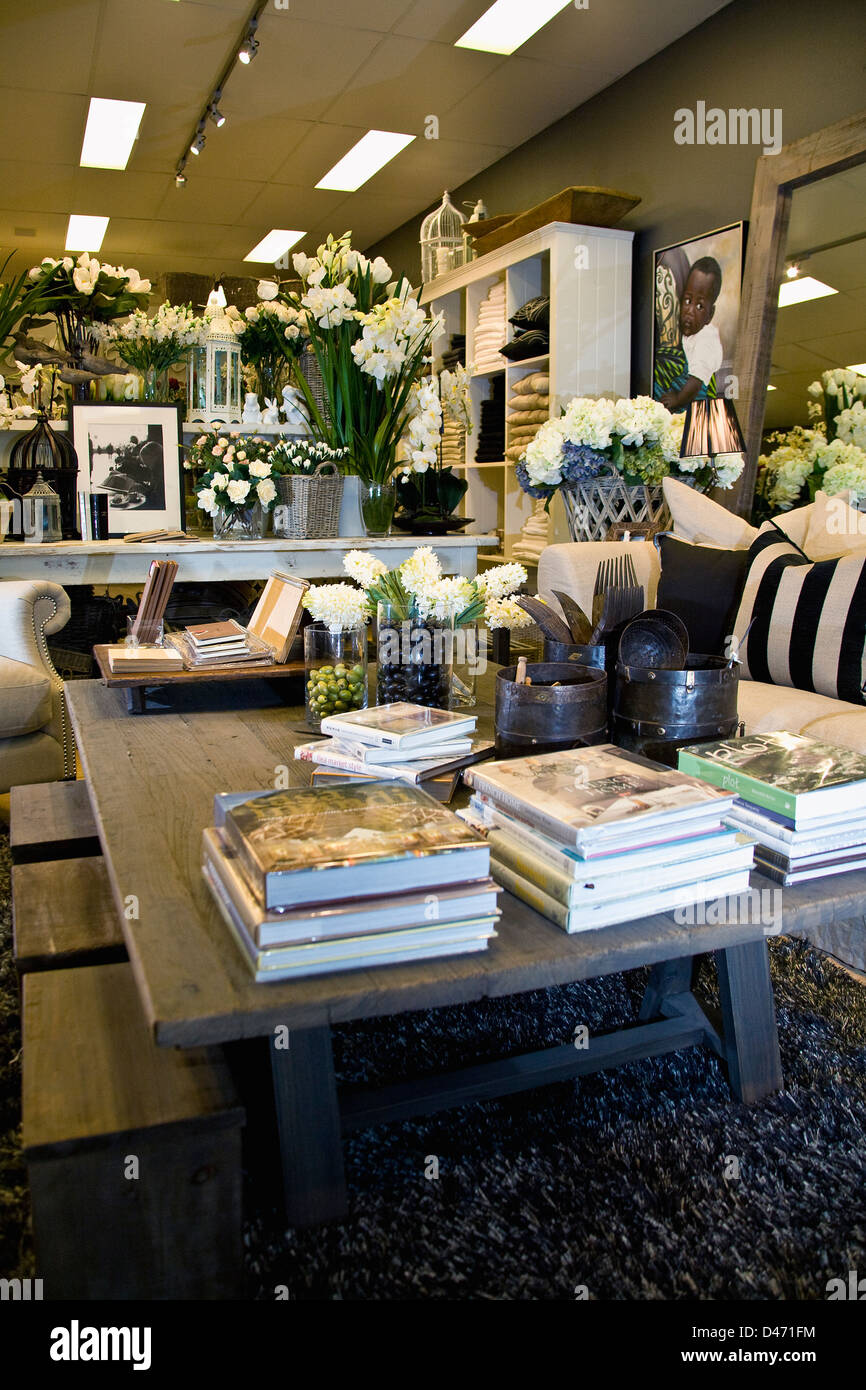 Image of homewares shop display with mock setting of a luxurious lounge room, books, tin pails and jars of native seed on table Stock Photo