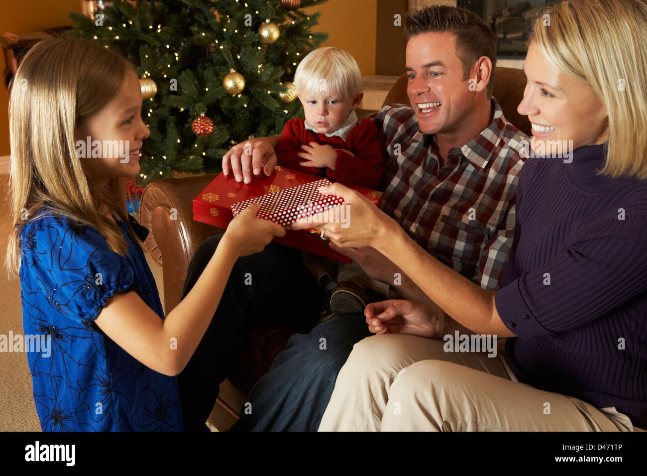 Family Opening Presents In Front Of Christmas Tree Stock Photo Alamy