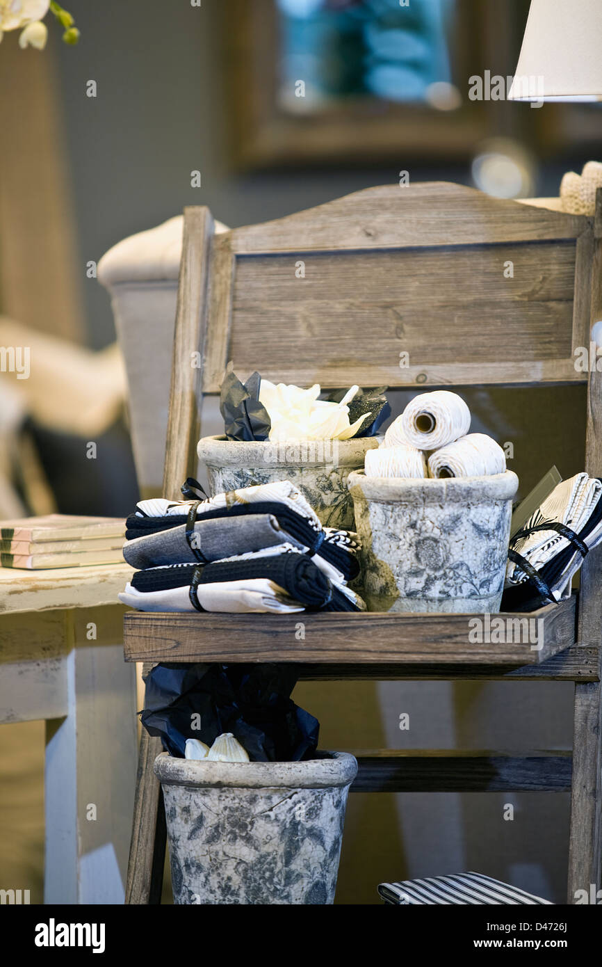 Folded and gift wrapped - tied kitchen towels and ceramic pots with rolls of string placed neatly on a wooden trestle. Stock Photo