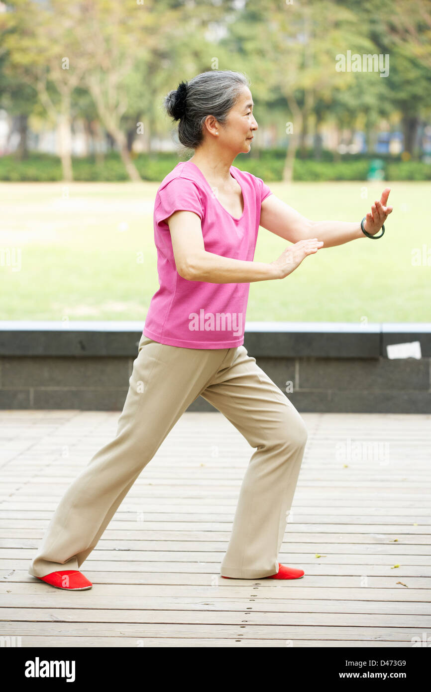 Senior Chinese Woman Doing Tai Chi In Park Stock Photo