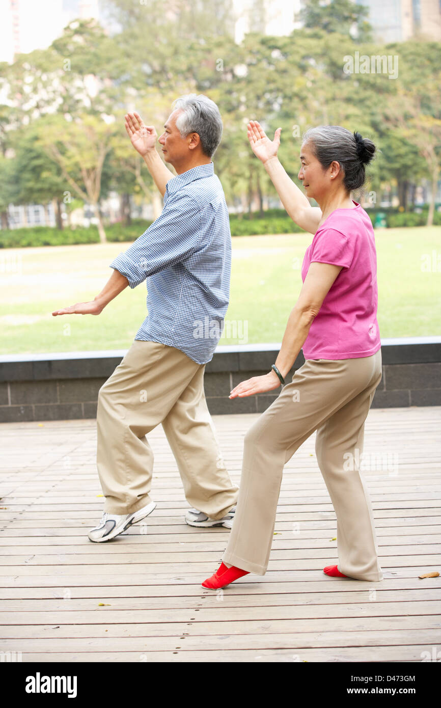 Senior Chinese Couple Doing Tai Chi In Park Stock Photo