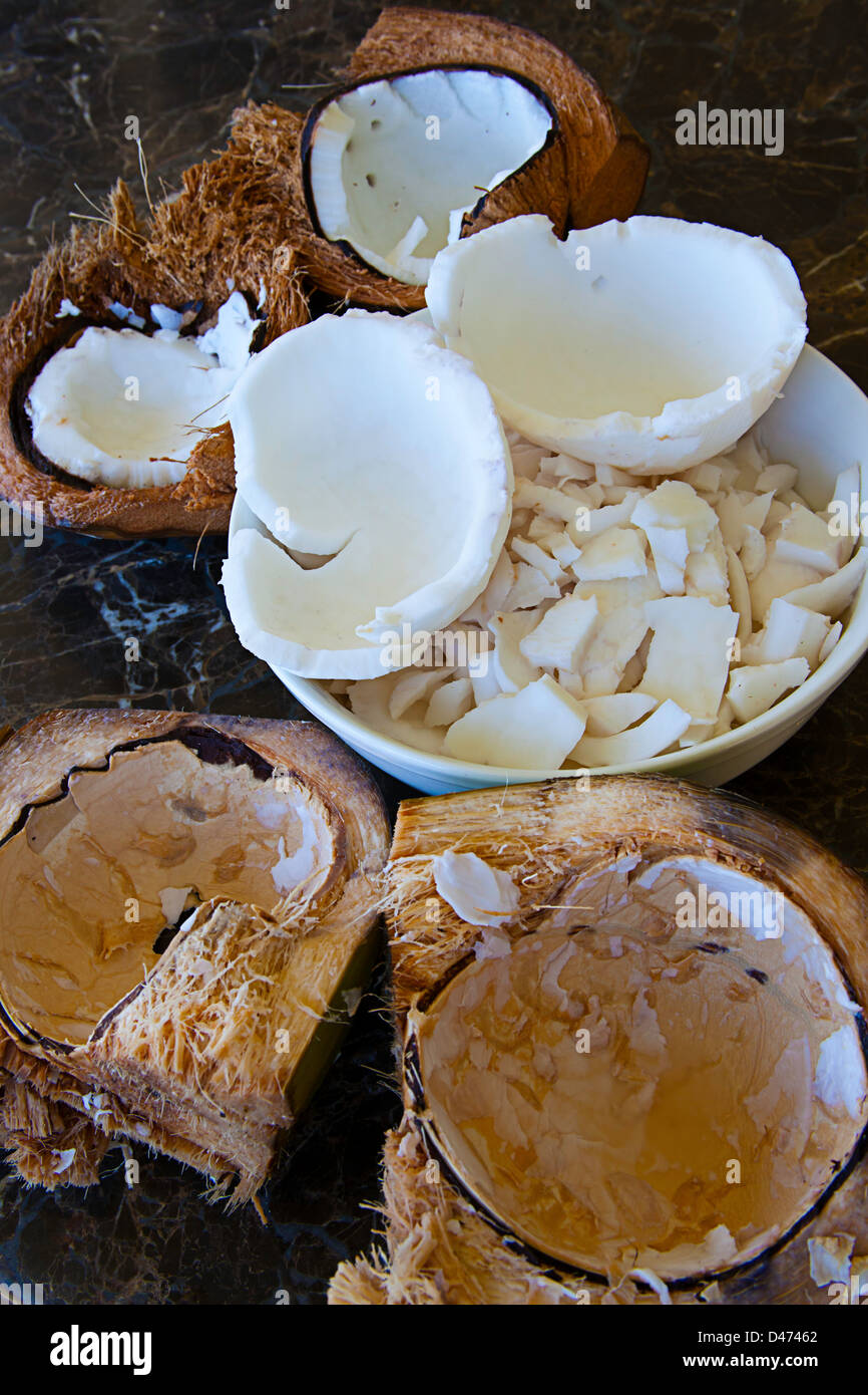Raw coconut in a bowl and split open with the husk, Hawaii. Stock Photo