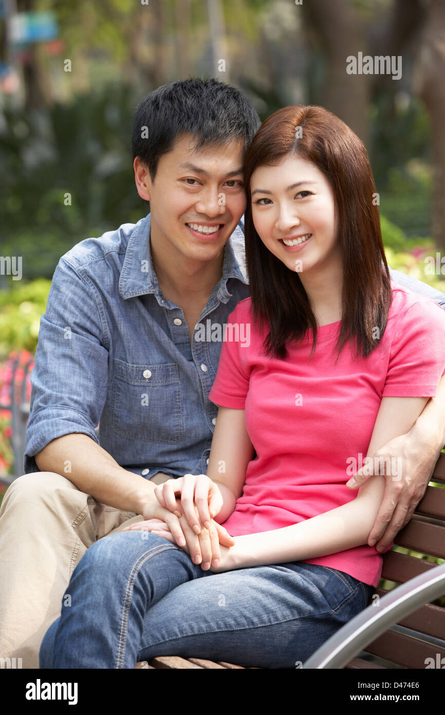 Young Chinese Couple Relaxing On Park Bench Together Stock Photo - Alamy