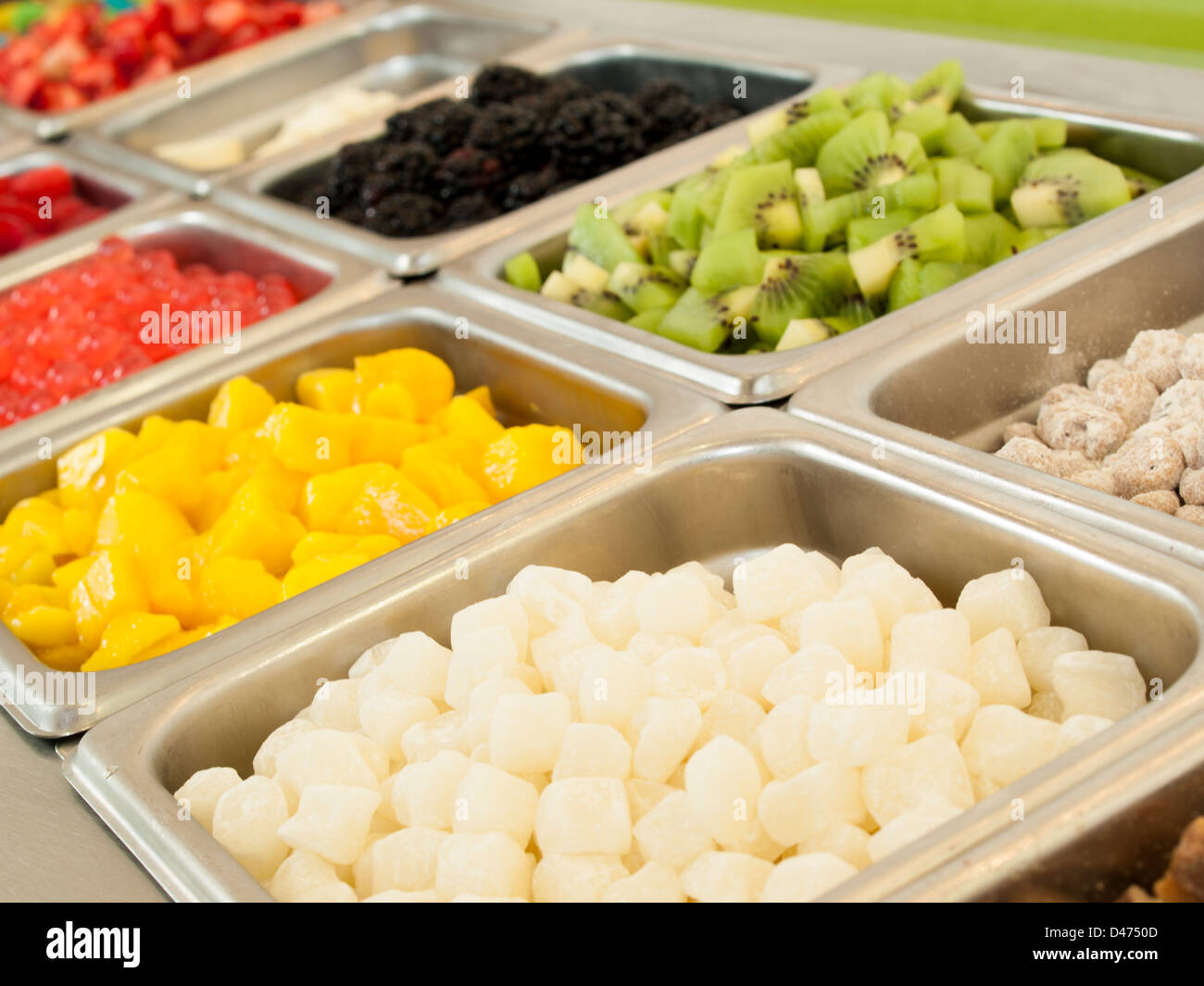 Frozen yogurt toppings bar. Yogurt toppings ranging from fresh fruits,  nuts, fresh-cut candies, syrups and sprinkles Stock Photo - Alamy