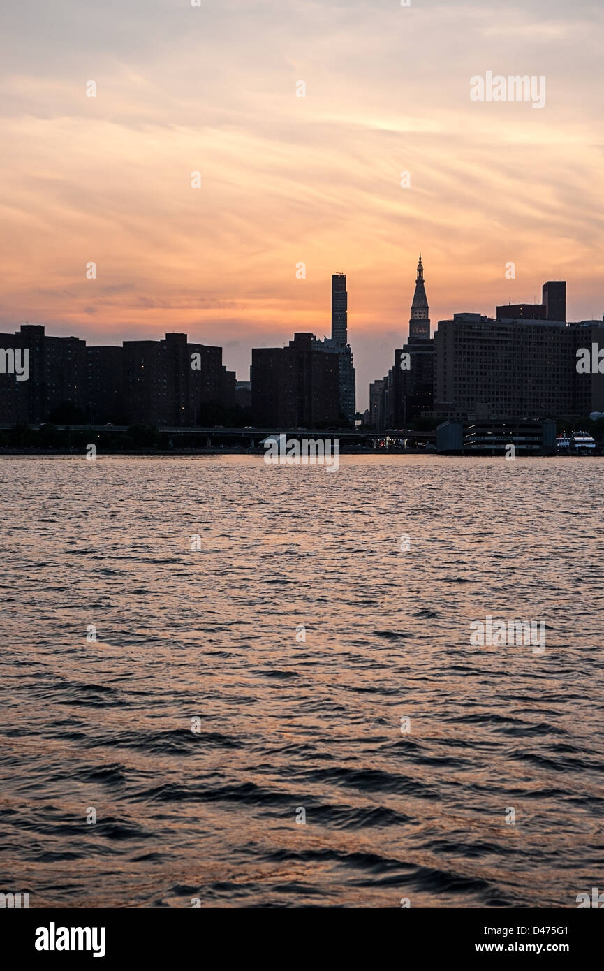 Silhouette of New York City skyline with skyscrapers over East River after sunset . Stock Photo