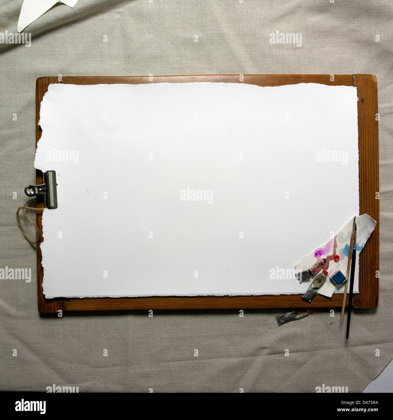 Artists board with watercolour paper and clip on a grey fabric background Stock Photo