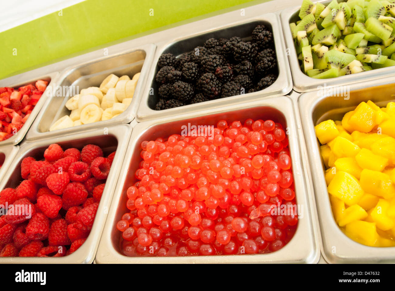 Frozen yogurt toppings bar. Yogurt toppings ranging from fresh fruits,  nuts, fresh-cut candies, syrups and sprinkles Stock Photo - Alamy