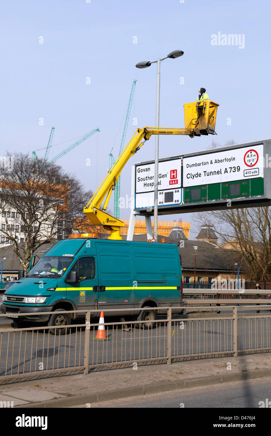 Council workers maintaining streetlights on a dual carriageway from a mounted aerial lift on a Glasgow City Council van, Scotland, UK Stock Photo