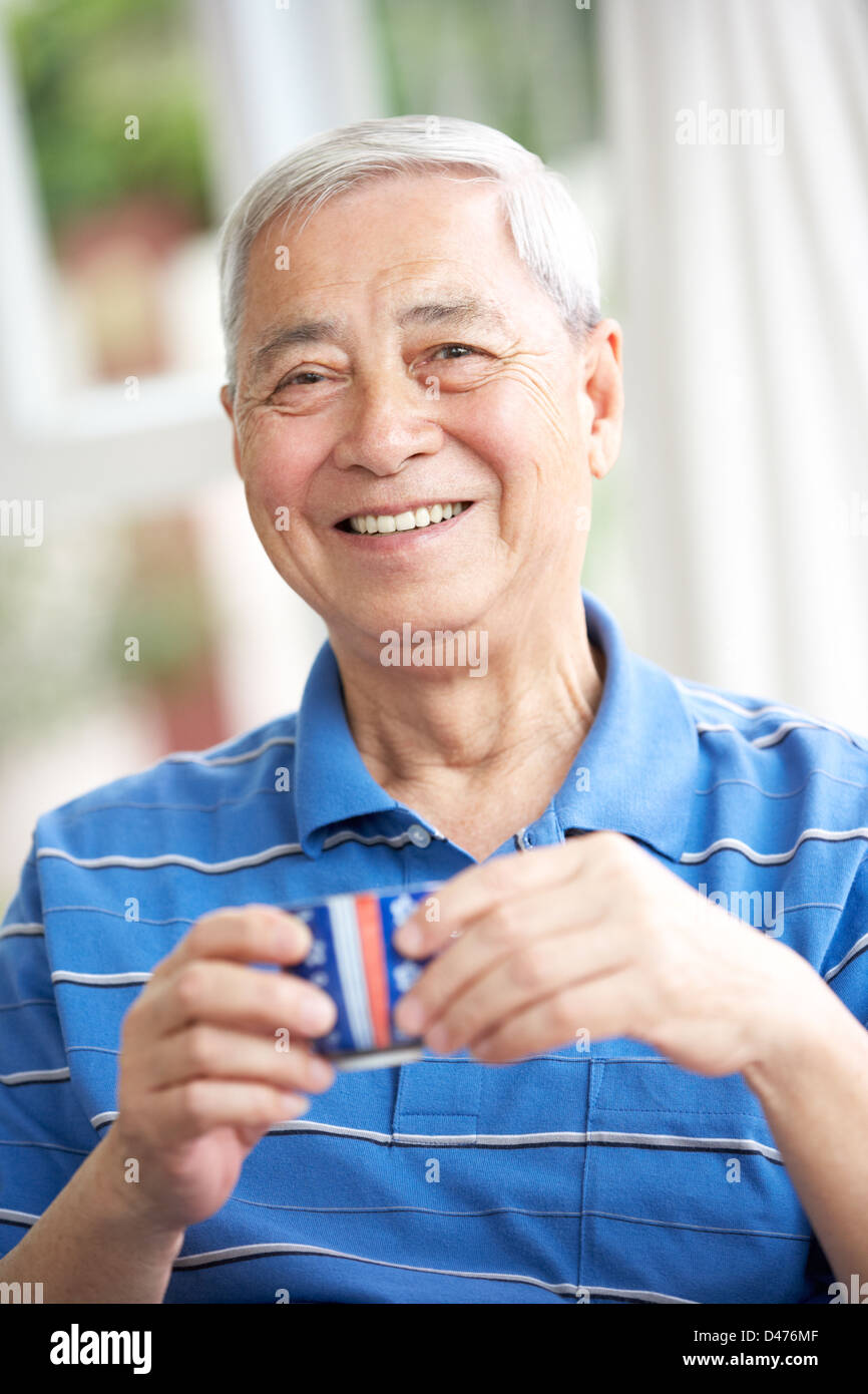 Senior Chinese Man Drinking Tea On Sofa At Home Stock Photo