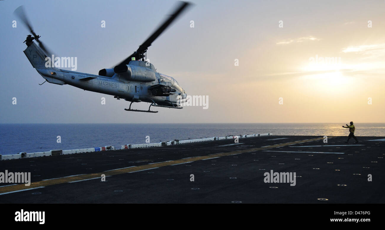 Sailor directs an AH-1 Cobra helicopter to take off from USS Boxer Stock Photo