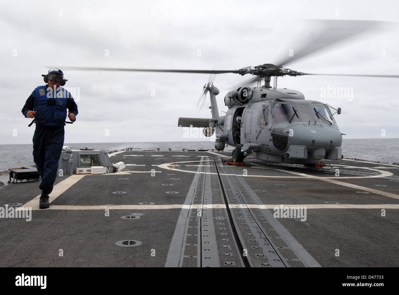 Boatswain's Mate 3rd Class Jeremy Hernandez complete chocking and chaining aboard USS Thach