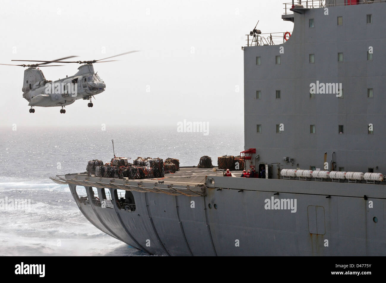 A CH-46E Sea Knight helicopter prepares to pick up supplies from USNS Leroy Grumman Stock Photo