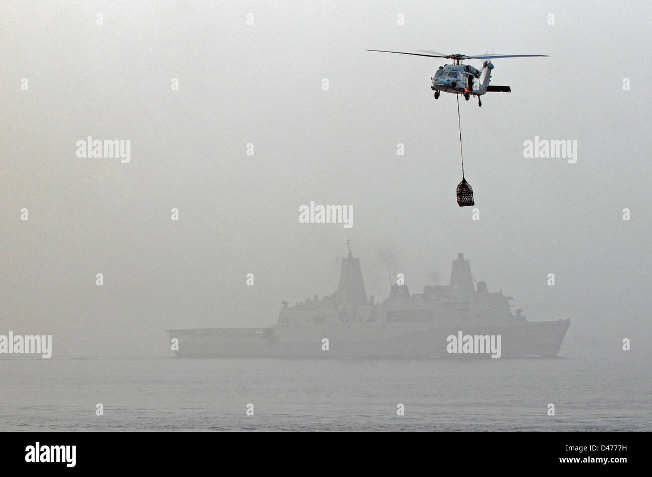 An MH-60S Sea Hawk helicopter carries supplies during underway replenishment evolution Stock Photo