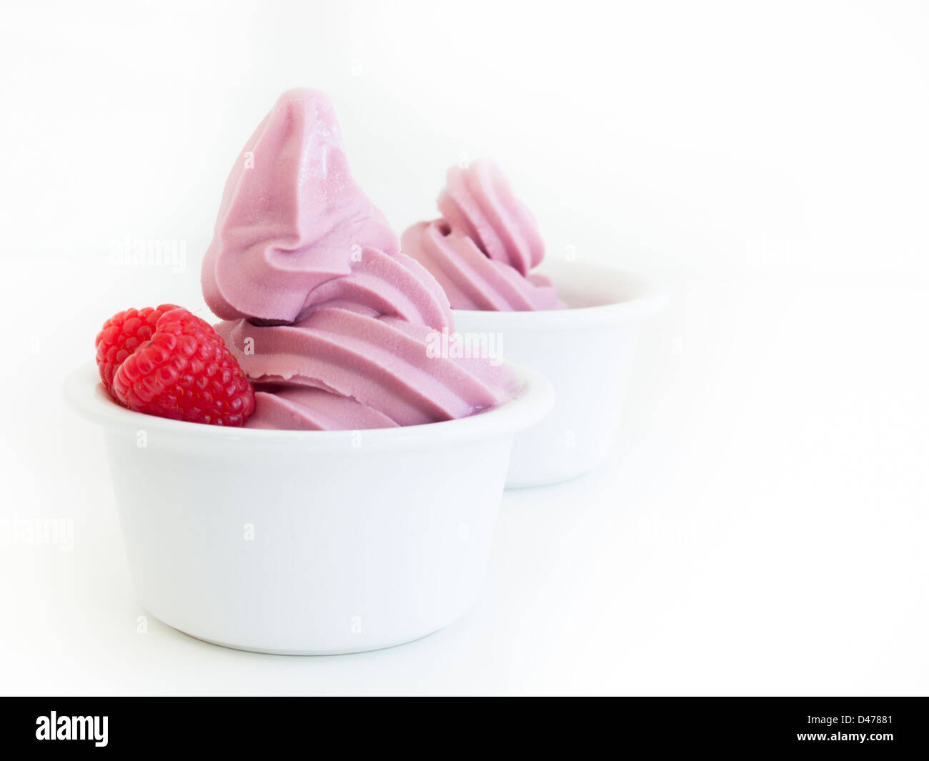 Frozen soft-serve yogurt in cup on white background. Stock Photo