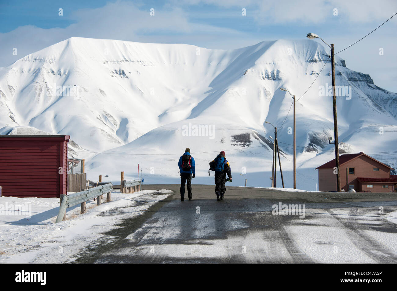 Two persons walking down a road in central Longyearbyen in Spitsbergen Stock Photo