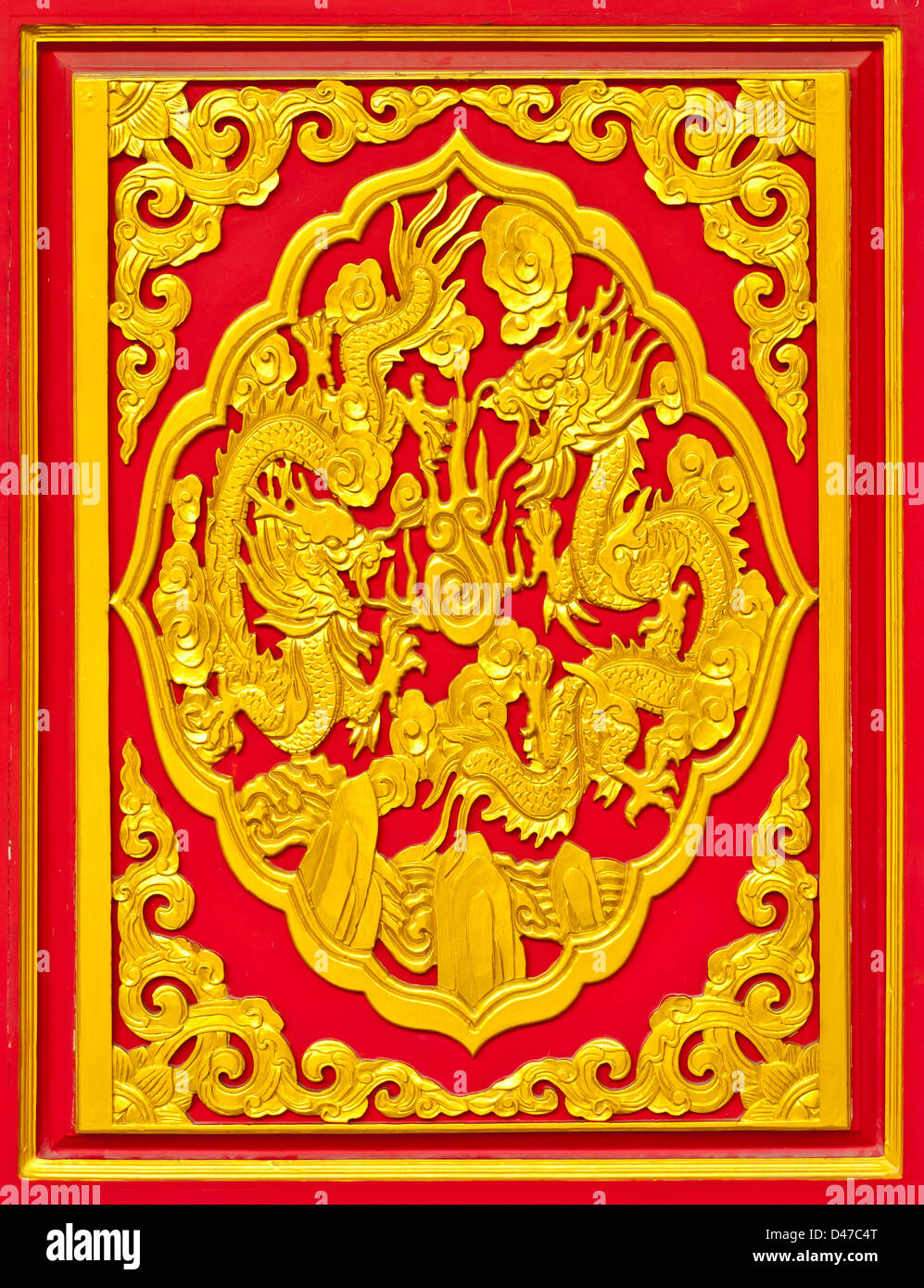 Chinese golden wood dragon sculpture on red background. Stock Photo