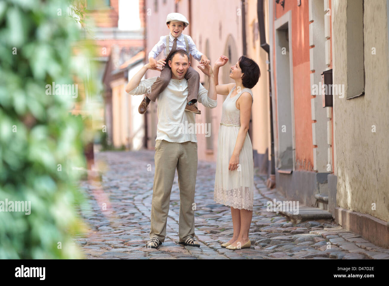 Happy young family in city street on beautiful summer day Stock Photo