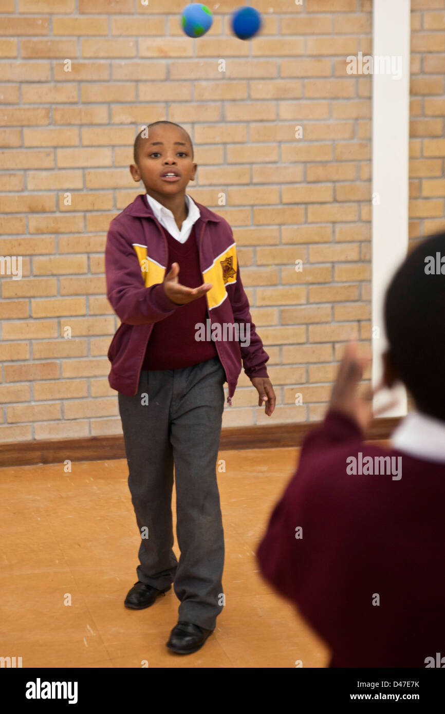 African school boys juggling balls as part of a circus class in hall of